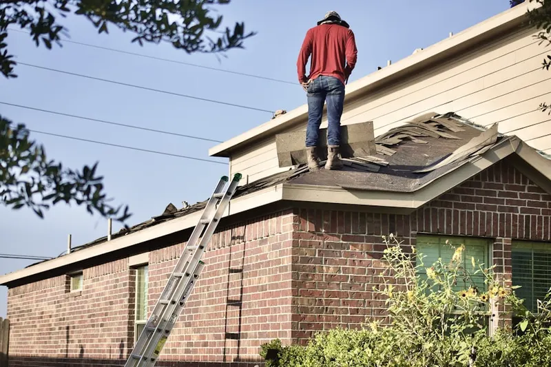 Professional roofer working on a residential roof in New Burlington